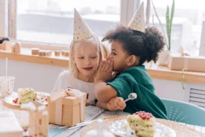 Two children wearing party hats, - Credits: pexels
