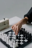Hand moving chess piece on - Credits: pexels