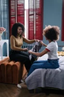 Two women sitting and chatting - Credits: pexels