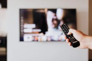 Person using a TV remote - Credits: pexels
