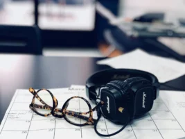 Glasses and headphones on a - Credits: pexels