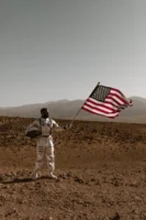 Astronaut proudly holds American flag - Credits: pexels