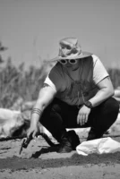 A man crouching outdoors using - Credits: pexels