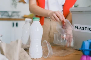 An adult woman sorts plastic - Credits: pexels