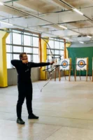 A man practicing archery indoors, - Credits: pexels